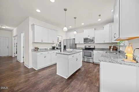 a kitchen with white cabinets stainless steel appliances and a counter top space