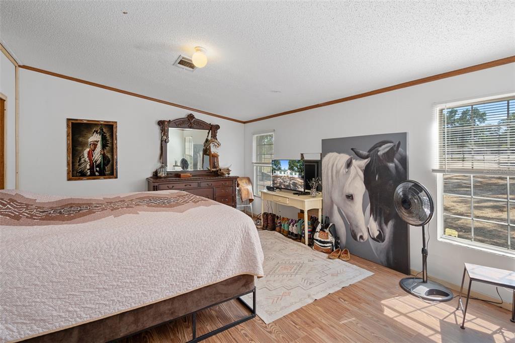 4059 McKethan Road Dade City, FL 33523 - Photo 28 of 50 a bedroom with a bed and wooden floor