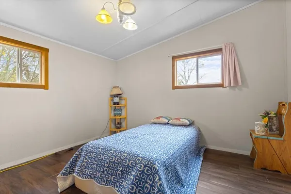 a bedroom with bed and painting on the wall