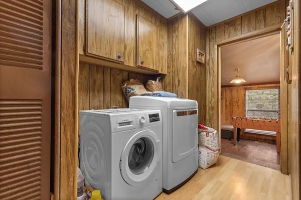a view of washer and dryer with bathroom in the background