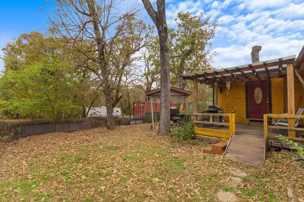 a view of a house with backyard and a tree
