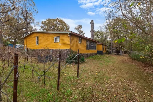 a blue house with tall trees