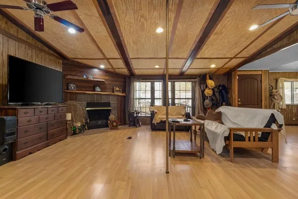a living room with furniture a flat screen tv and a fireplace