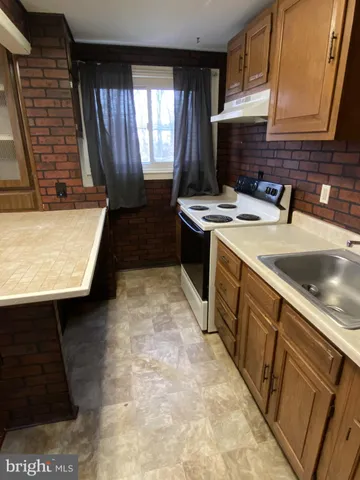 a kitchen with a sink stove and cabinets