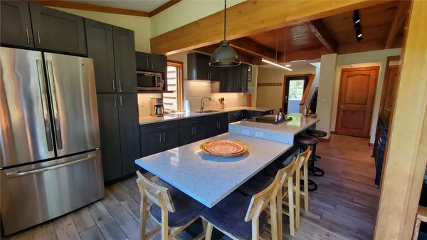 a view of a dining room with furniture a kitchen and wooden floor