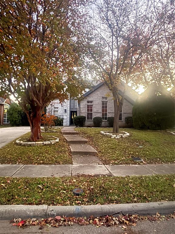 View of front of property with a front yard and brick siding