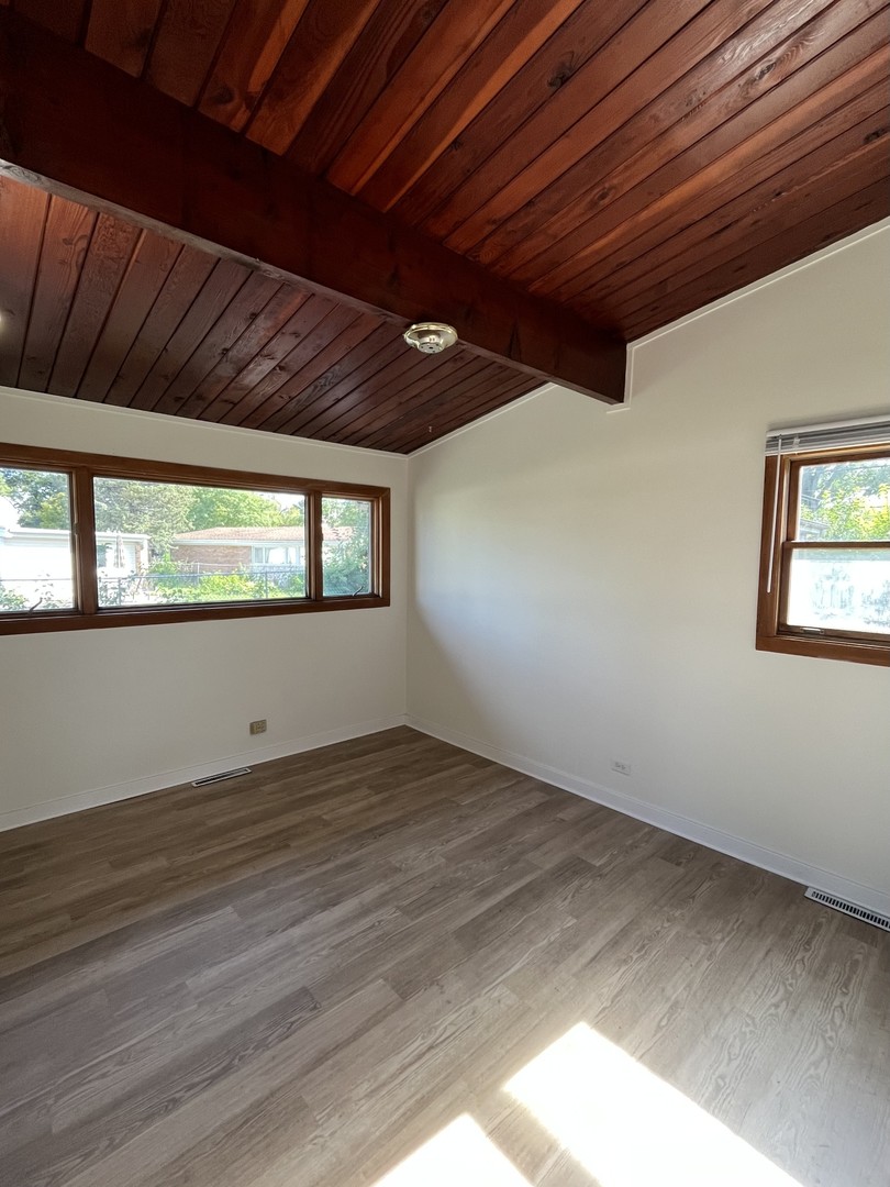 137 Highview Avenue Addison, IL 60101 - Photo 8 of 12 a view of an empty room with wooden floor and a window