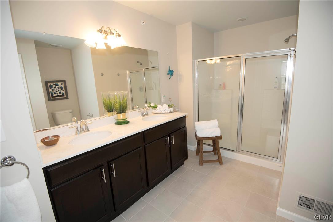 407 Pennycress Road Allentown, PA 18104 - Photo 16 of 34 a bathroom with a double vanity sink a toilet and a mirror