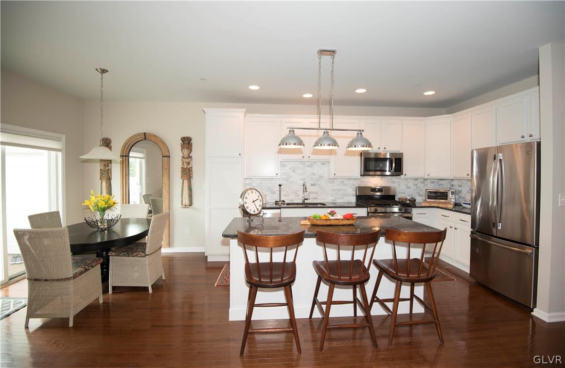 407 Pennycress Road Allentown, PA 18104 - Photo 6 of 34 a kitchen with stainless steel appliances granite countertop a dining table chairs refrigerator and sink