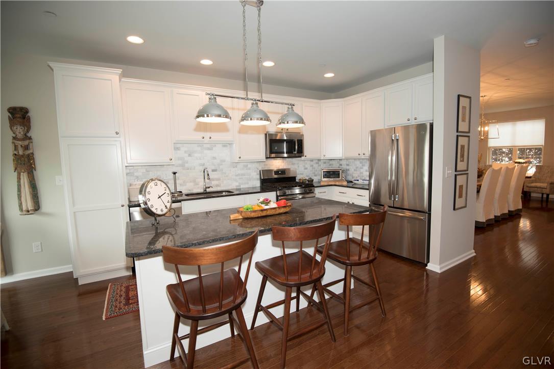 407 Pennycress Road Allentown, PA 18104 - Photo 7 of 34 a kitchen with stainless steel appliances granite countertop a refrigerator a stove a sink a dining table and chairs with wooden floor