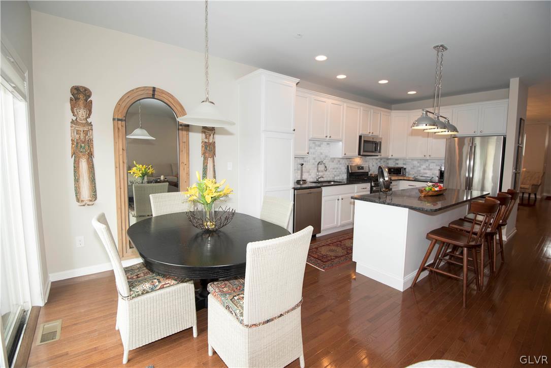 407 Pennycress Road Allentown, PA 18104 - Photo 8 of 34 a kitchen with stainless steel appliances kitchen island granite countertop a dining table chairs and white cabinets