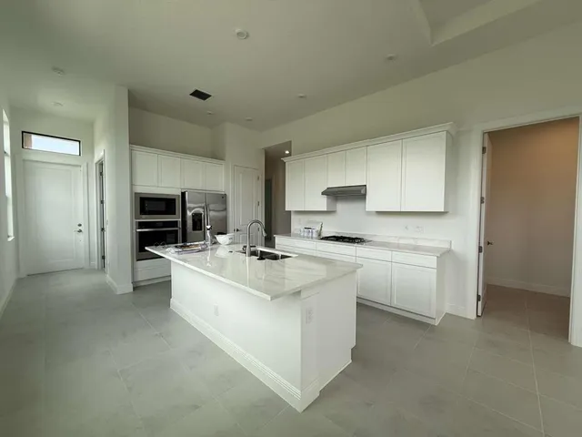 a large white kitchen with cabinets