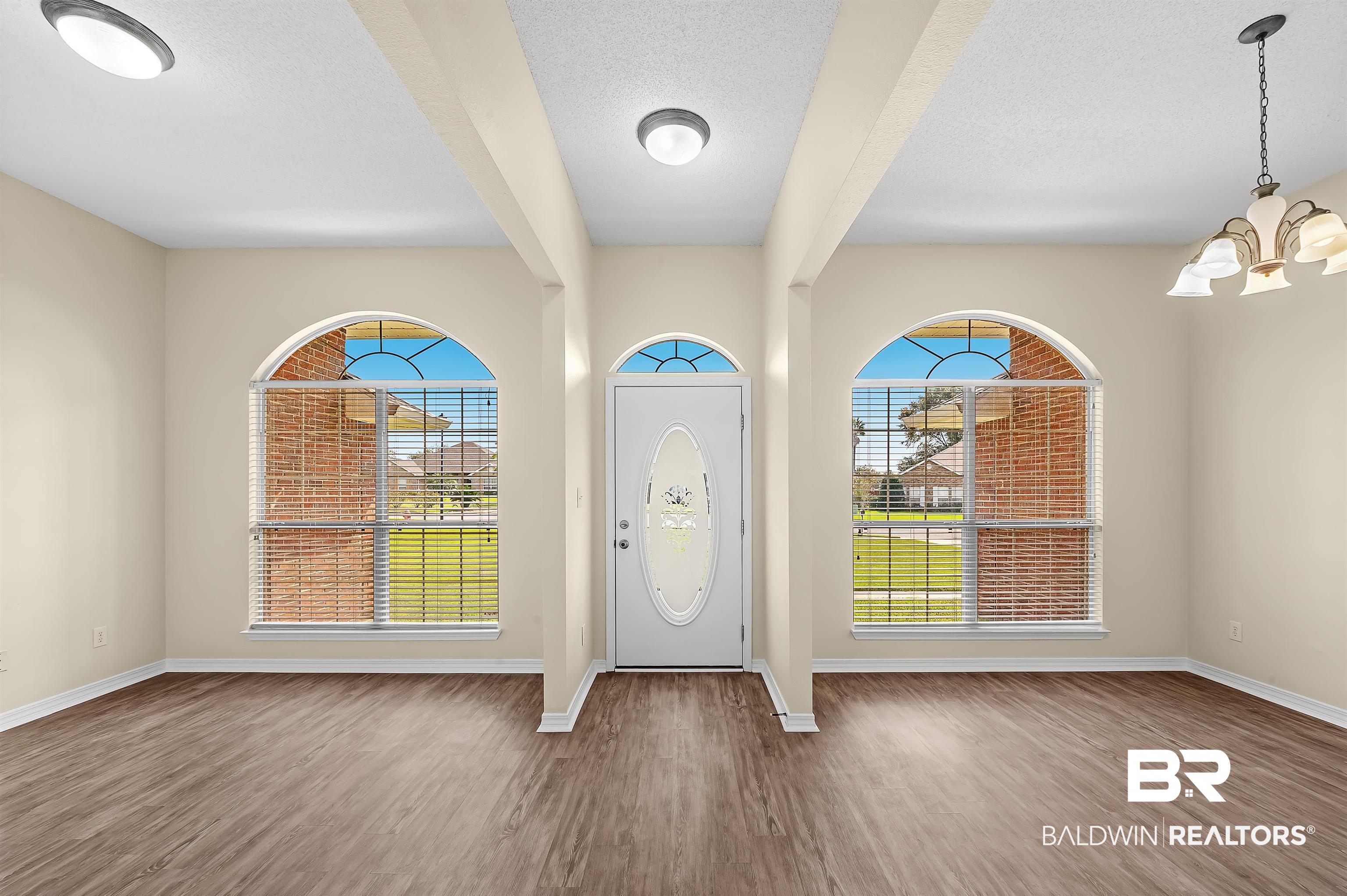 12443 Venice Boulevard Foley, AL 36535 - Photo 11 of 59 Foyer with a wealth of natural light, hardwood / wood-style flooring, and a chandelier