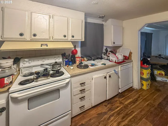 a kitchen with white cabinets and white appliances
