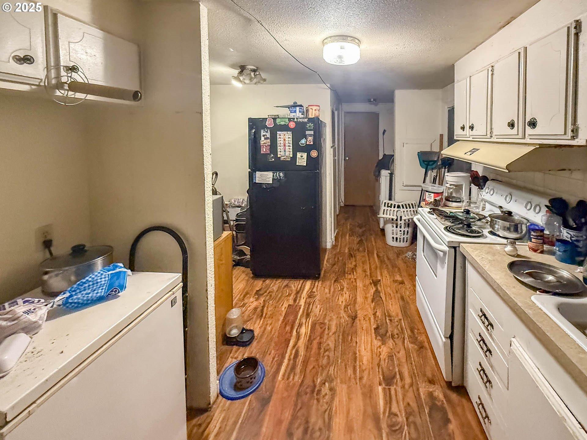 301 Conrad Street Myrtle Creek, OR 97457 - Photo 6 of 12 a kitchen with stainless steel appliances granite countertop a refrigerator a stove and white cabinets with wooden floor
