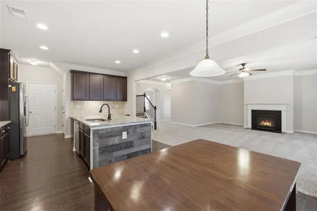 a kitchen with stainless steel appliances granite countertop a stove a sink refrigerator and wooden floor