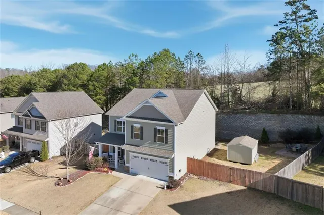 a view of a white house with large windows and a tree