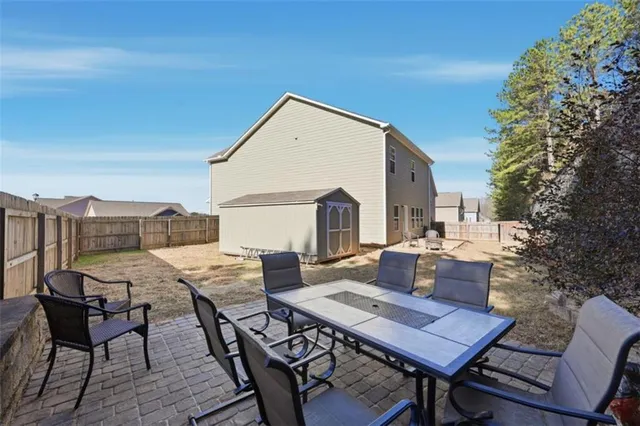 a backyard of a house with table and chairs