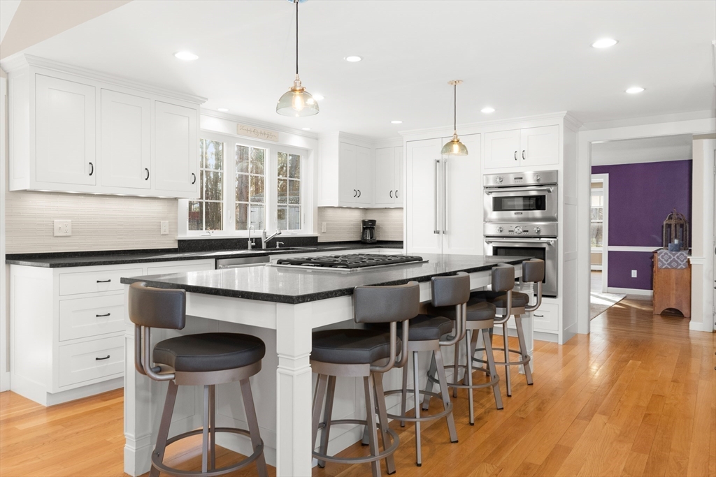 32 Alderbrook Drive Topsfield, MA 01983 - Photo 6 of 40 a kitchen with stainless steel appliances granite countertop a stove a refrigerator a kitchen island a stove and white cabinets with wooden floor