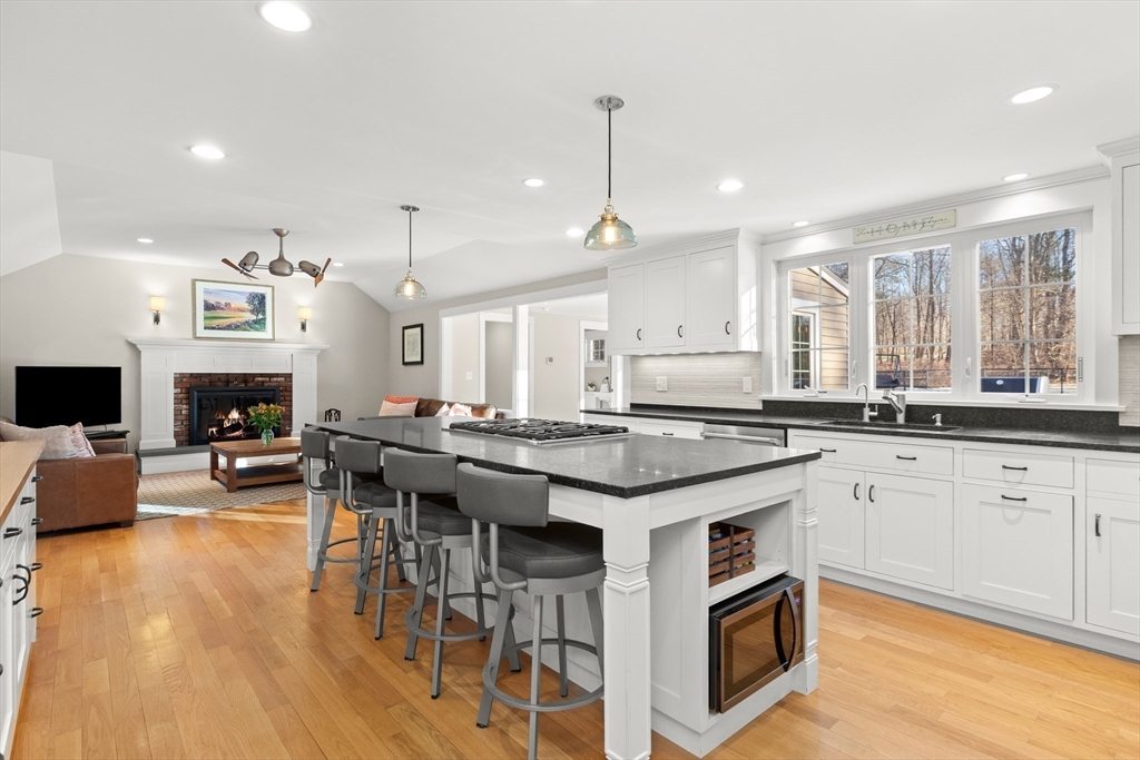 32 Alderbrook Drive Topsfield, MA 01983 - Photo 8 of 40 a kitchen with stainless steel appliances granite countertop a stove a sink dishwasher a refrigerator and a dining table with wooden floor