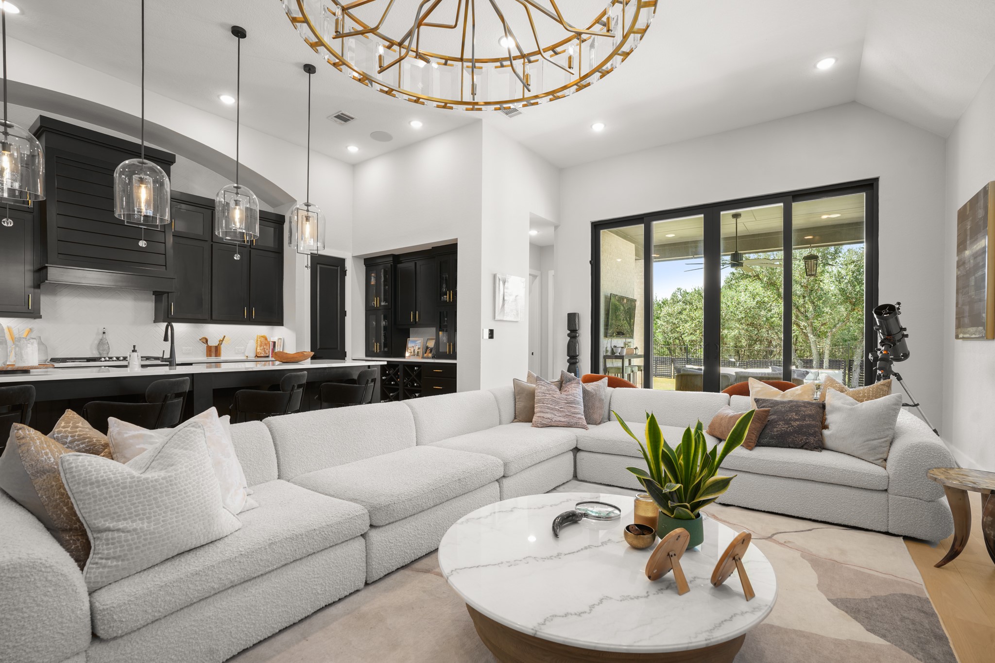 154 LITTLE Strm Cove Austin, TX 78737 - Photo 8 of 37 Towering ceilings and glass sliding doors enhance the modern, open-concept living area.