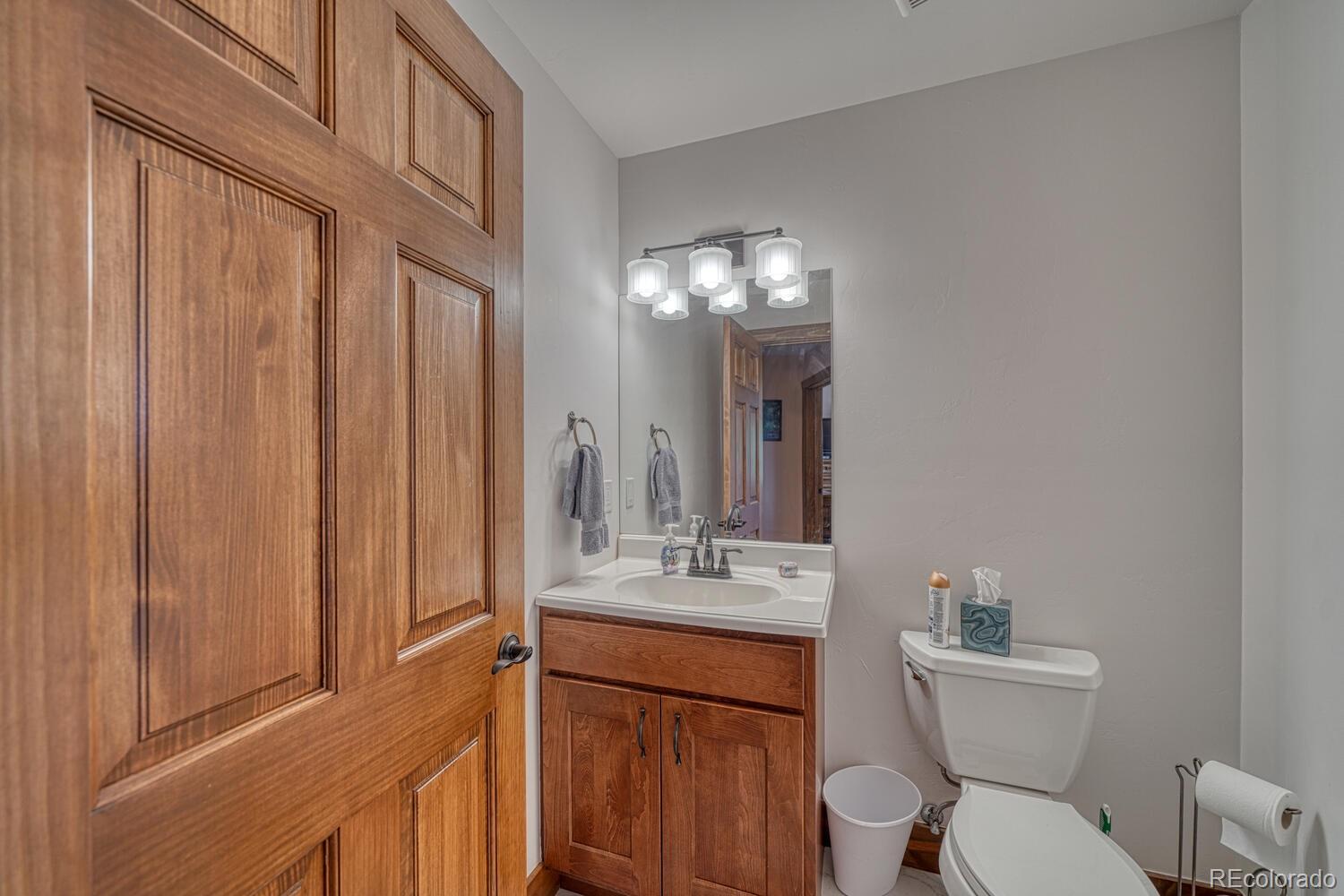441 Kaufman Road Hartsel, CO 80449 - Photo 23 of 50 a bathroom with a toilet a sink a mirror a vanity and window