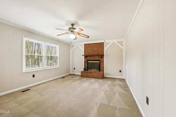 a view of empty room with window and ceiling fan