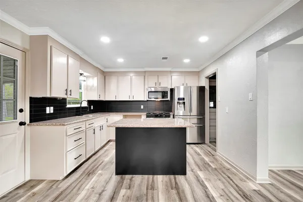 a kitchen with a refrigerator a sink and cabinets