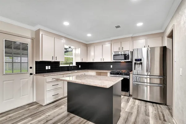 a kitchen with stainless steel appliances granite countertop a sink stove and refrigerator