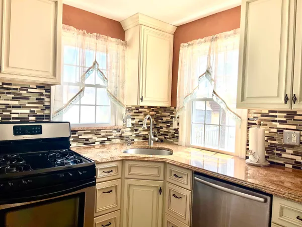 a kitchen with a stove a sink and a window