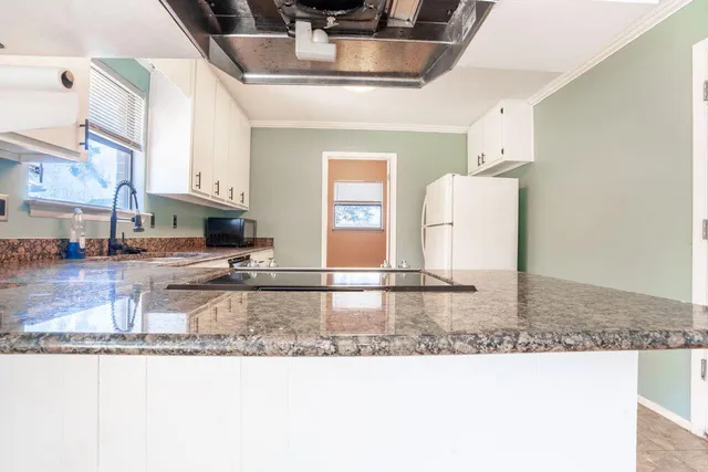 a kitchen with stainless steel appliances granite countertop a sink and a stove
