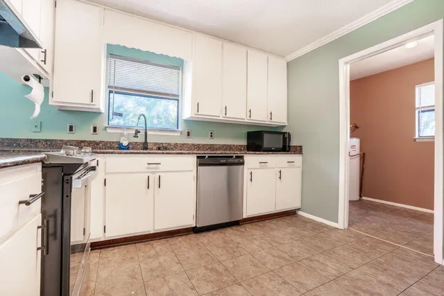 a kitchen with granite countertop white cabinets white stainless steel appliances and sink