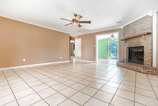 a view of a livingroom with a chandelier fan and fire place