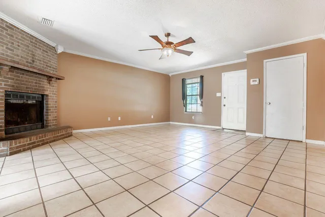 a view of an empty room and window and chandelier fan