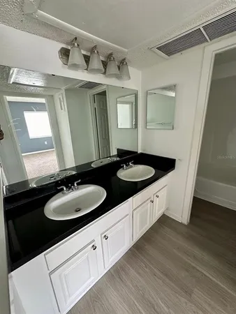 a bathroom with a double vanity sink and mirror