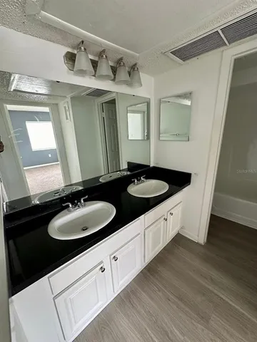 a bathroom with a double vanity sink and mirror