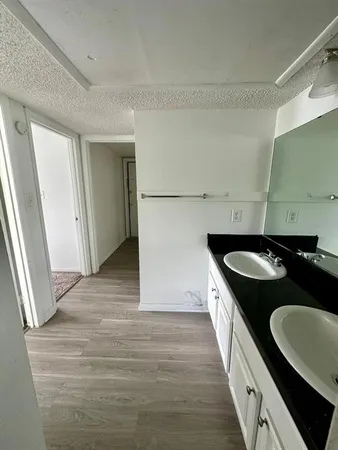 a kitchen with granite countertop a sink stove and cabinets