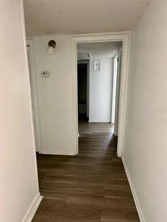 a view of a hallway with wooden floor