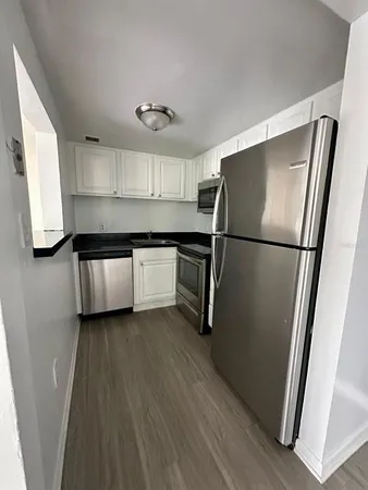 a kitchen with stainless steel appliances a refrigerator sink and cabinets