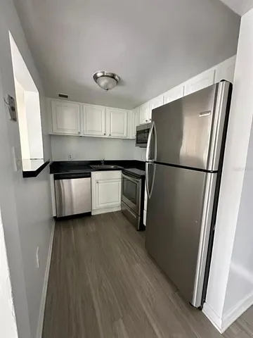 a kitchen with stainless steel appliances a refrigerator sink and cabinets
