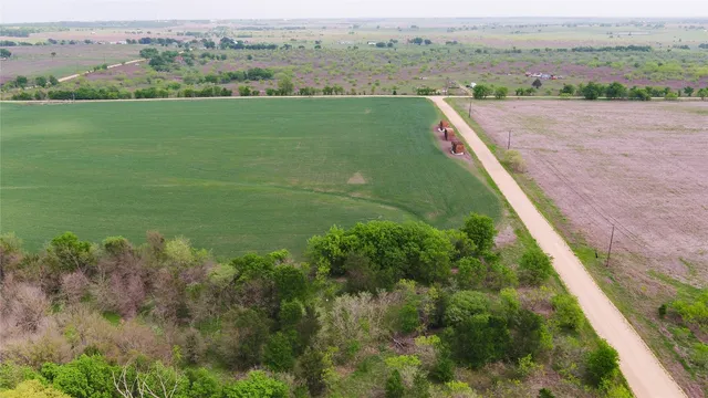 an aerial view of green landscape with trees houses and lake view