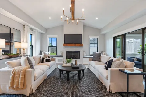 a living room with furniture a fireplace and a large window