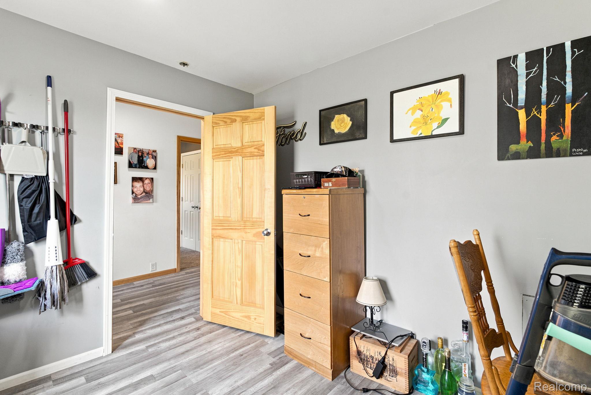 4201 Galbraith Line Road Croswell, MI 48422 - Photo 22 of 39 Interior space featuring light gray walls, wood-finish flooring, and a natural wood paneled door
