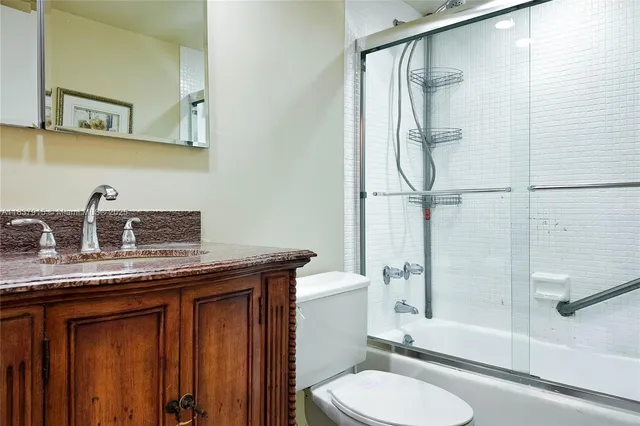 a bathroom with a granite countertop sink toilet and shower