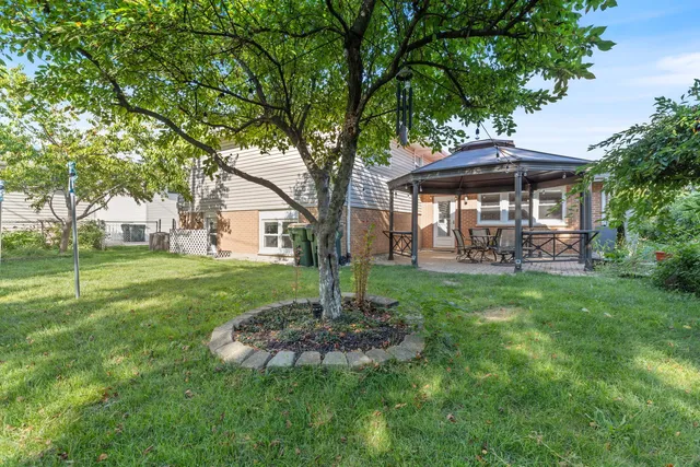 a front view of a house with garden and trees