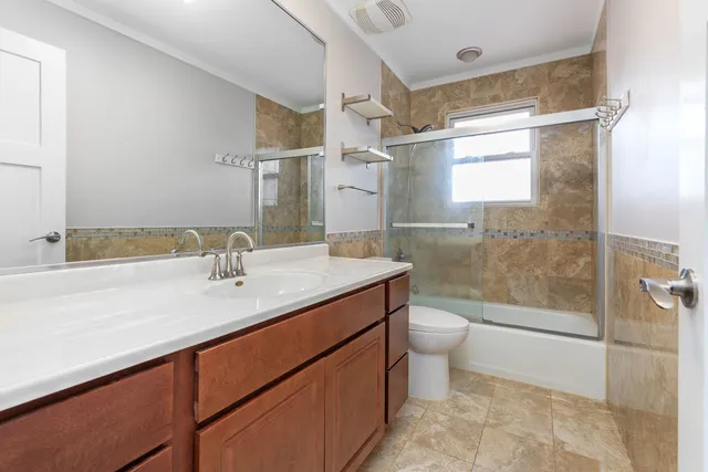 a bathroom with a granite countertop sink toilet and shower
