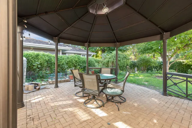a view of patio with table and chairs under an umbrella