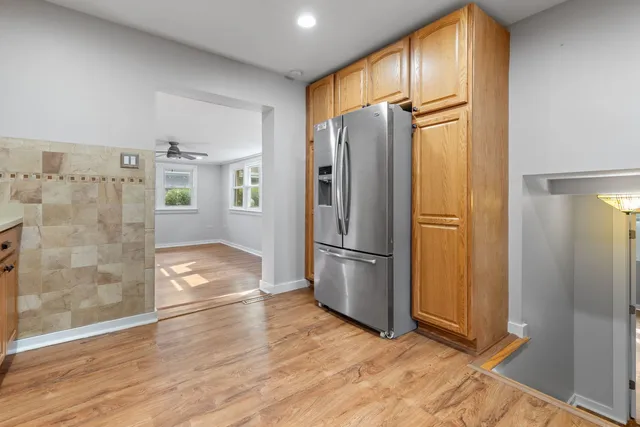 a view of a kitchen with wooden floor and refrigerator
