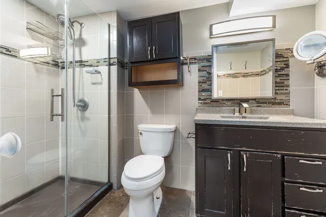 a bathroom with a sink a toilet and shower