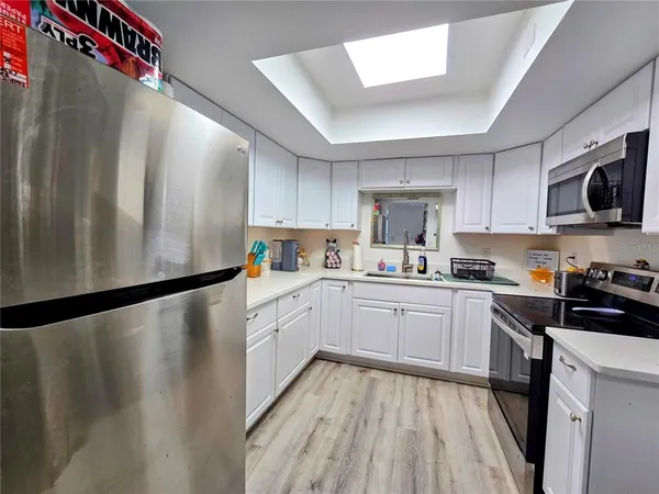 a kitchen with a refrigerator a sink and cabinets